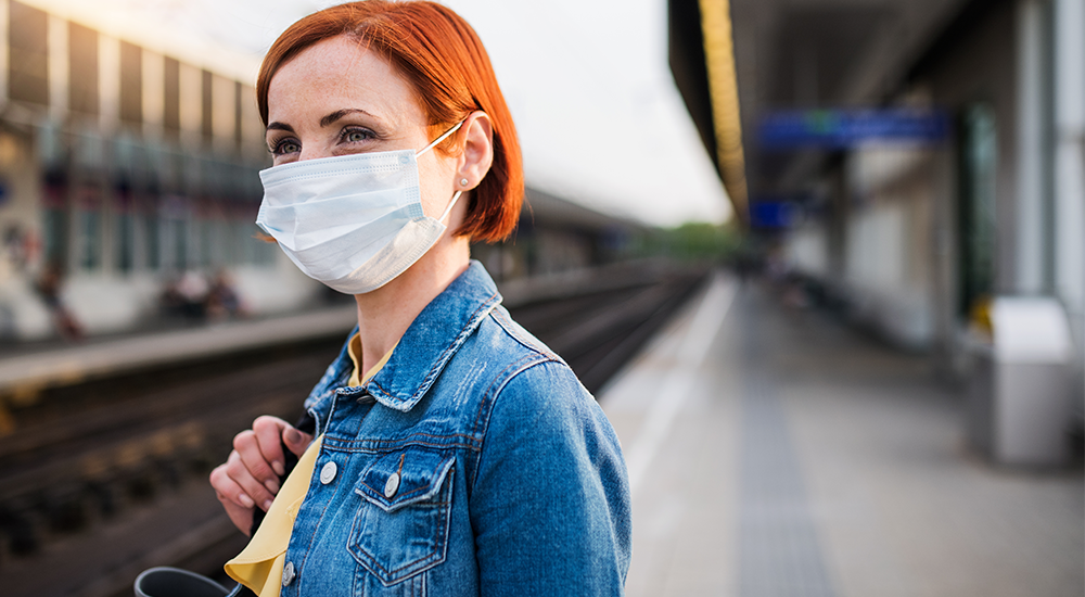 woman wearing a mask while waiting for the train